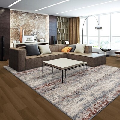 Living room with maroon grey and white area rug under a brown couch with a white coffee table with black metal legs.